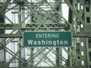 Road signs on the Interstate 5 bridge welcomes drivers to Washington.