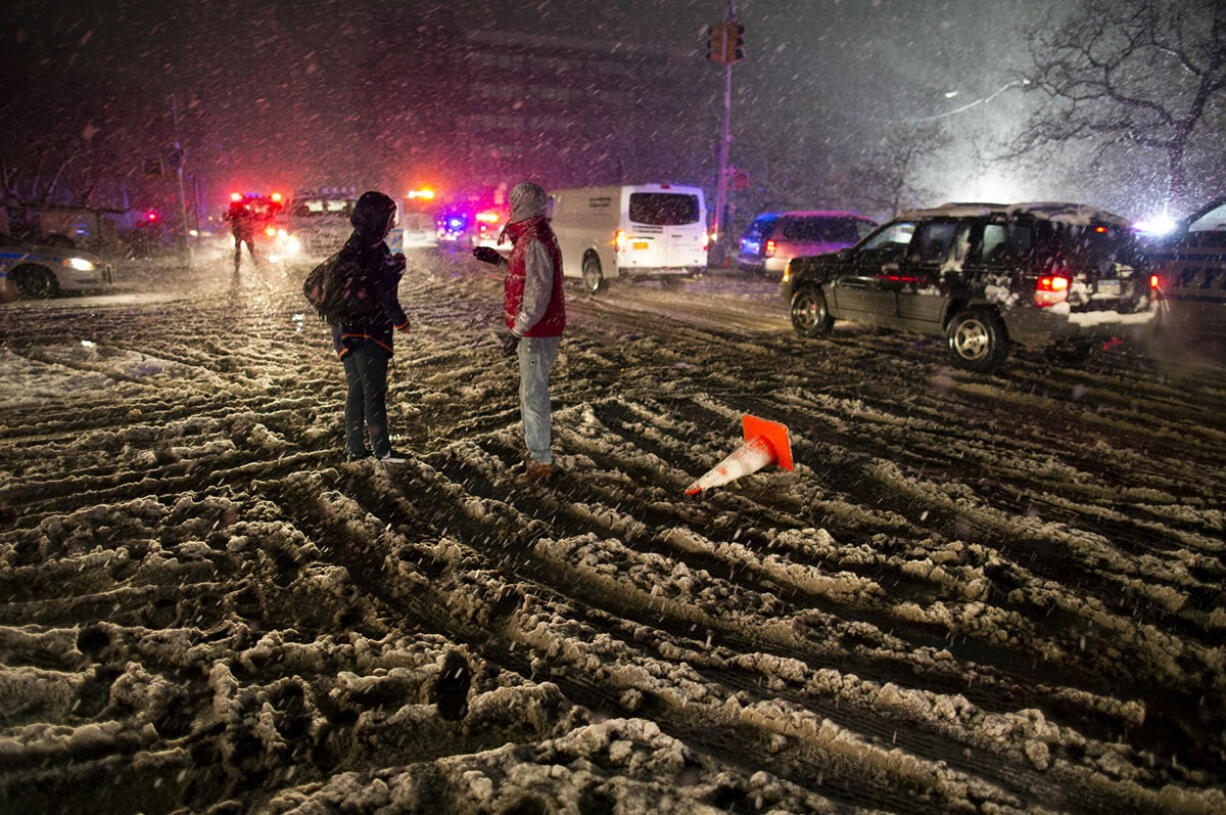 People walk through snow as it accumulates in the Rockaway Beach neighborhood of the borough of Queens, New York, on Wednesday in the wake of Superstorm Sandy.