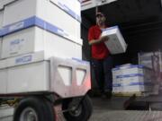 An SAIA employee unloads copy paper from a delivery truck Friday at Centennial Tower in downtown Atlanta.