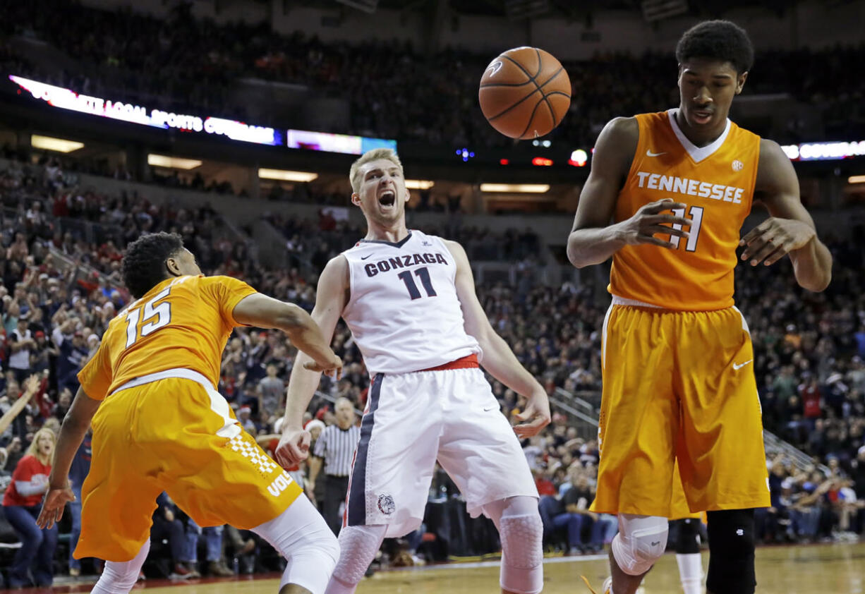 Gonzaga forward Domantas Sabonis (11) reacts after he dunked against Tennessee forward Kyle Alexander, right, and guard Detrick Mostella, left, during the second half of an NCAA college basketball game Saturday, Dec. 19, 2015, in Seattle. Gonzaga beat Tennessee 86-79. (AP Photo/Ted S.