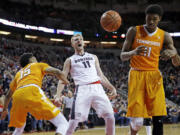 Gonzaga forward Domantas Sabonis (11) reacts after he dunked against Tennessee forward Kyle Alexander, right, and guard Detrick Mostella, left, during the second half of an NCAA college basketball game Saturday, Dec. 19, 2015, in Seattle. Gonzaga beat Tennessee 86-79. (AP Photo/Ted S.