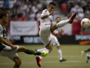 Vancouver Whitecaps Camilo Sanvezzo, right, fights for control of the ball with Portland Timbers Jack Jewsbury, left, during first half Sunday.