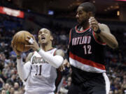 Milwaukee Bucks' Monta Ellis (11) drives past Portland Trail Blazers' LaMarcus Aldridge during the second half of an NBA basketball game Tuesday, March 19, 2013, in Milwaukee. The Bucks won 102-95.