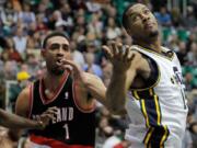 Utah Jazz forward Derrick Favors, right, looks to grab a rebound against Portland Trail Blazers forward Jared Jeffries (1) in the first half Friday.