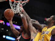 Portland Trail Blazers guard Nolan Smith, left, takes a shot against Los Angeles Lakers center Robert Sacre, middle, and forward Earl Clark (6) during the second half Friday.