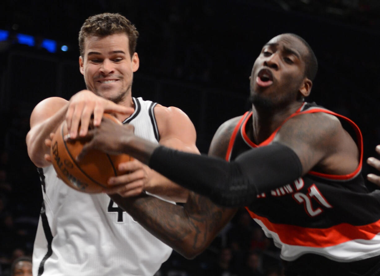 Brooklyn Nets' Kris Humphries, left, and Portland Trail Blazers' J.J. Hickson battle for the ball in the third quarter Sunday.