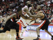 Houston's James Harden, center, is fouled by Portland Trail Blazers' Nolan Smith, right, as Wesley Matthews, left, reaches in in the second half Saturday.