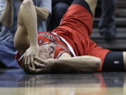 Portland Trail Blazers' Meyers Leonard holds his head after he was injured during the first half of an NBA basketball game against the San Antonio Spurs, Friday, March 8, 2013, in San Antonio.