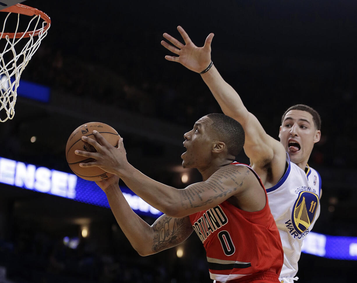 Portland Trail Blazers' Damian Lilliard (0) shoots past Golden State Warriors' Klay Thompson during the second half of an NBA basketball game Friday, Jan. 11, 2013, in Oakland, Calif.