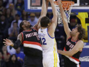 Portland Trail Blazers' LaMarcus Aldridge, left, blocks a shot attempt from Golden State Warriors' Andrew Bogut (12) during the first half of an NBA preseason basketball game on Thursday, Oct. 24, 2013, in Oakland, Calif.