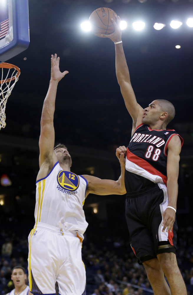 Nicolas Batum shoots over Golden State's Andrew Bogut during a preseason game Oct. 24.