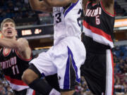 Sacramento Kings' guard Marcus Thornton (23) drives to the basket past Portland Trail Blazers' defenders, Meyers Leonard (11) and Will Barton (5) during Sunday's game.