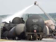 Firefighters water railway cars the day after a train derailed causing explosions of railway cars carrying crude oil in Lac Megantic, Quebec, on July 7.