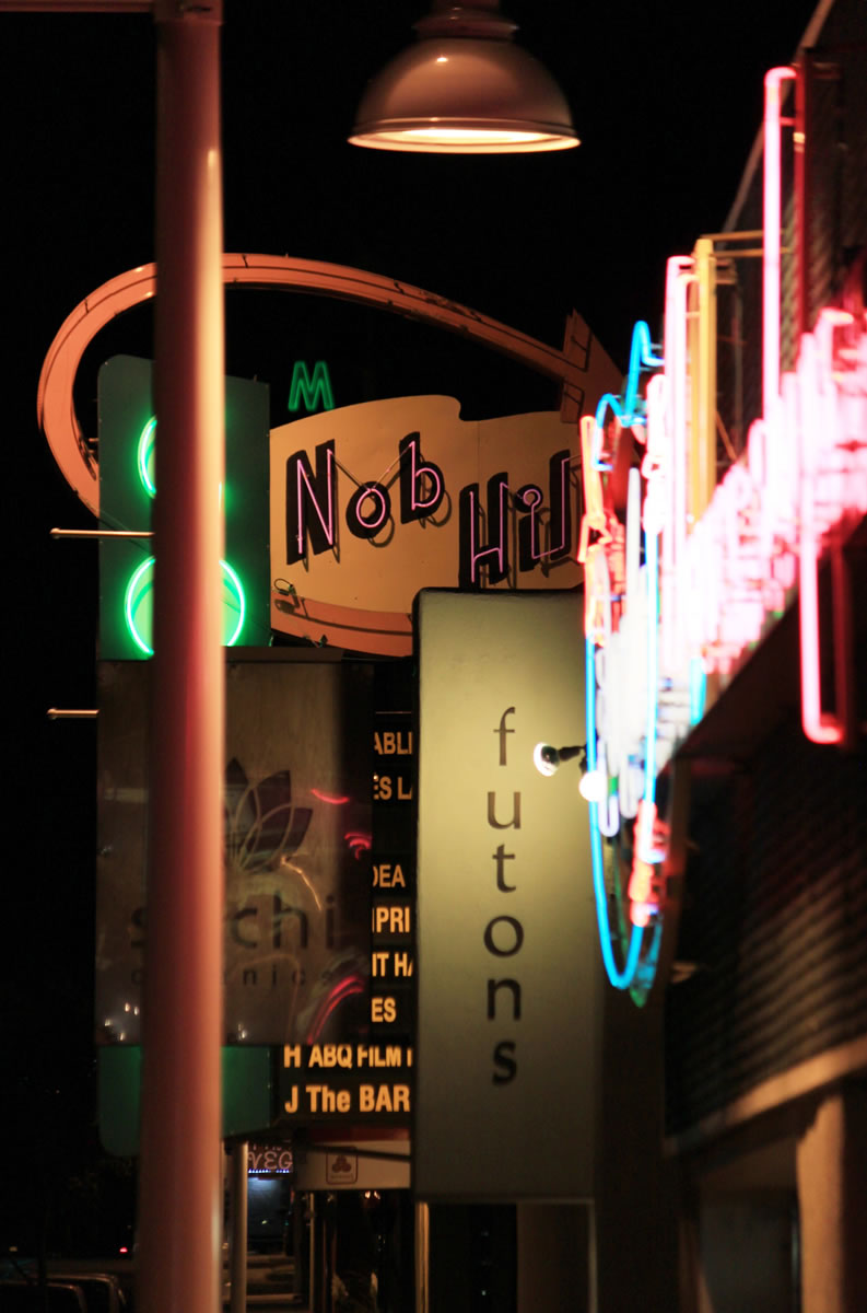 Vintage and modern neon signs hangs above the sidewalk in the Nob Hill district along historic Route 66 in Albuquerque.