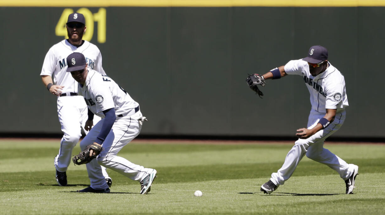 Seattle Mariners right fielder Endy Chavez, right, races to the ball from Minnesota Twins' Chris Colabello that fell between center fielder Dustin Ackley, left, and second baseman Nick Franklin in the fourth inning Saturday.