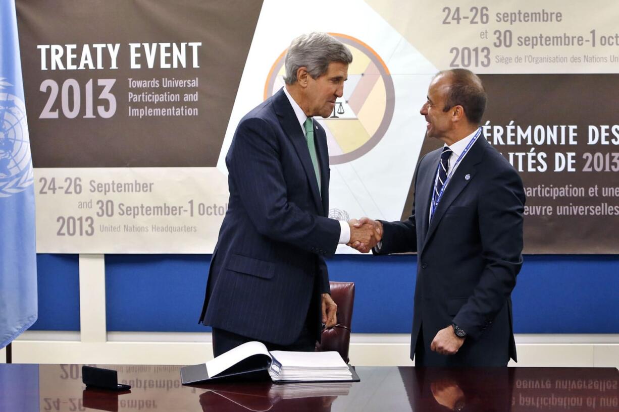 U.S. Secretary of State John Kerry, left, shakes hands with Under Secretary-General for Legal Affairs Miguel Serpa Soares after signing the Arms Trade Treaty during the 68th session of the United Nations General Assembly at U.N.