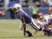 Washington quarterback Keith Price (17) flicks off a pass under pressure against Southern California during the first half Saturday.