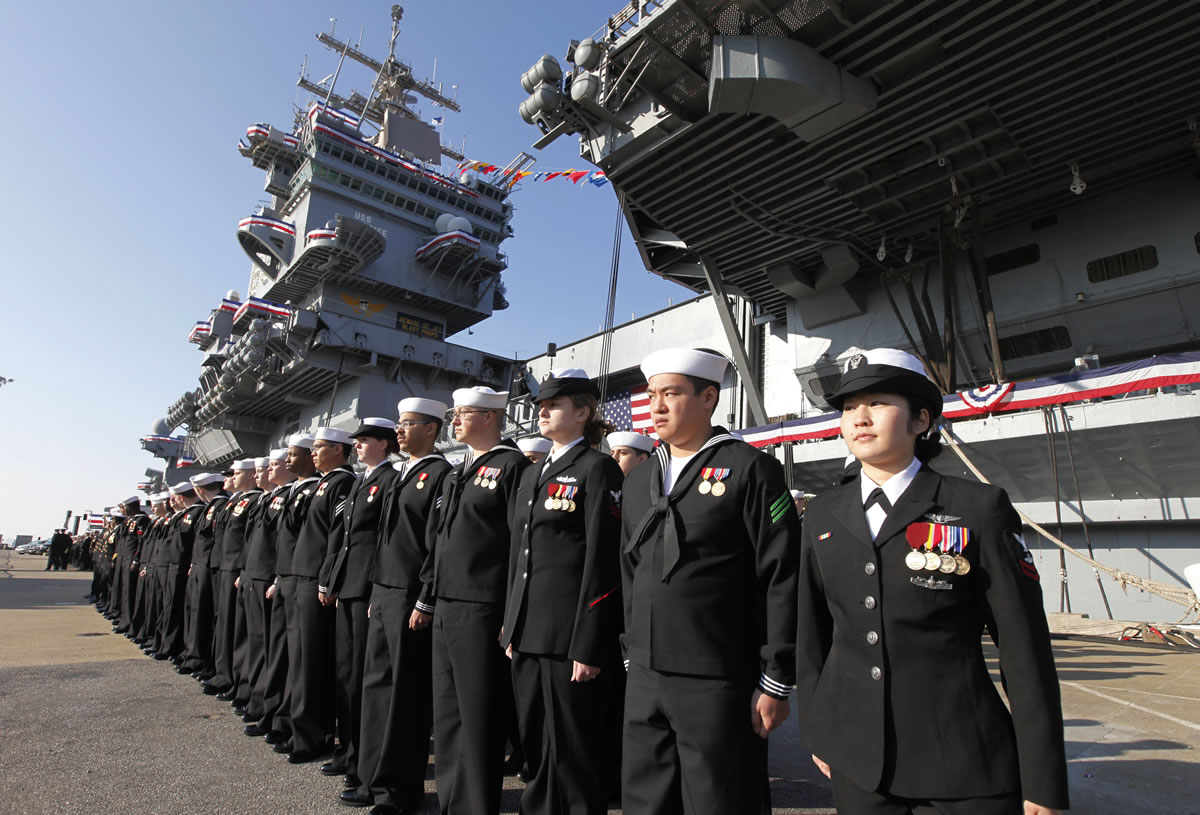 The crew of the USS Enterprise stands at attention after disembarking the ship during the Dec. 1 retirement ceremony at Naval Station Norfolk in Virginia.