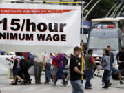 Demonstrators protest what they say are low wages and improper treatment for fast-food workers march in downtown Seattle on Aug.