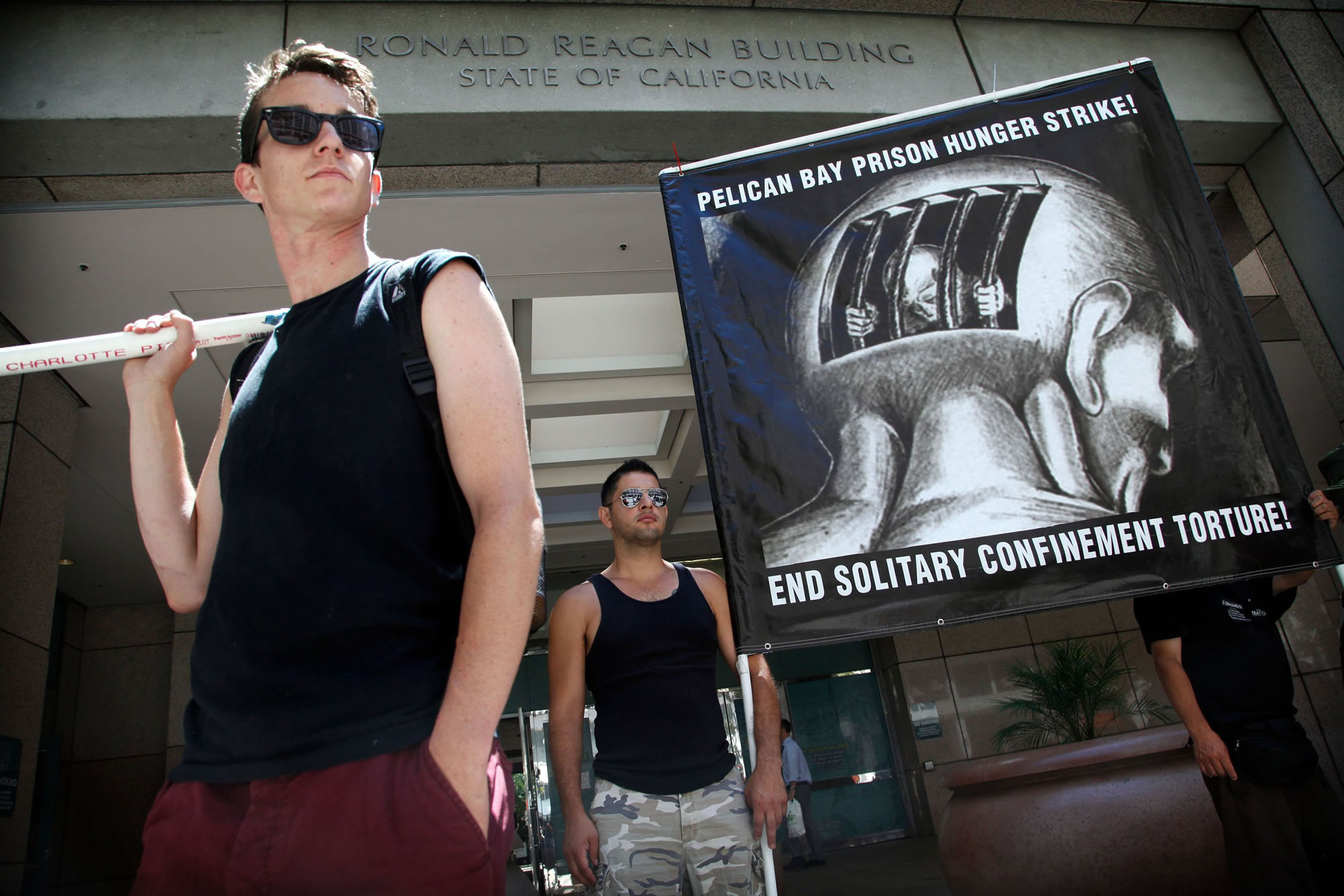 Gray Fisher, left, of California Prison Hunger Strike Solidarity Network, and Oscar Romero, of Stop Mass Incarceration Network, join demonstrators Monday in Los Angeles for a rally held in support of Pelican Bay State Prison inmates who are on a hunger strike in protest of state prisons' conditions.