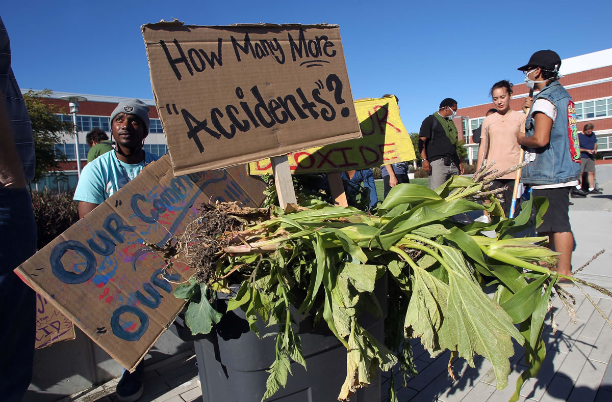 Members of the Richmond, Calif.,  group Urban Tilth  protest before the Chevron town hall meeting at the Richmond Memorial Auditorium in Richmond on Tuesday, Aug. 7, 2012. Investigators are waiting for access to the charred crude oil unit of a Chevron refinery where a fire sent a towering plume of black smoke into San Francisco Bay area skies and pushed gas prices higher along the West Coast. Hundreds of people went to hospitals with respiratory issues during the fire; crowds are lining up to file claims against Chevron.