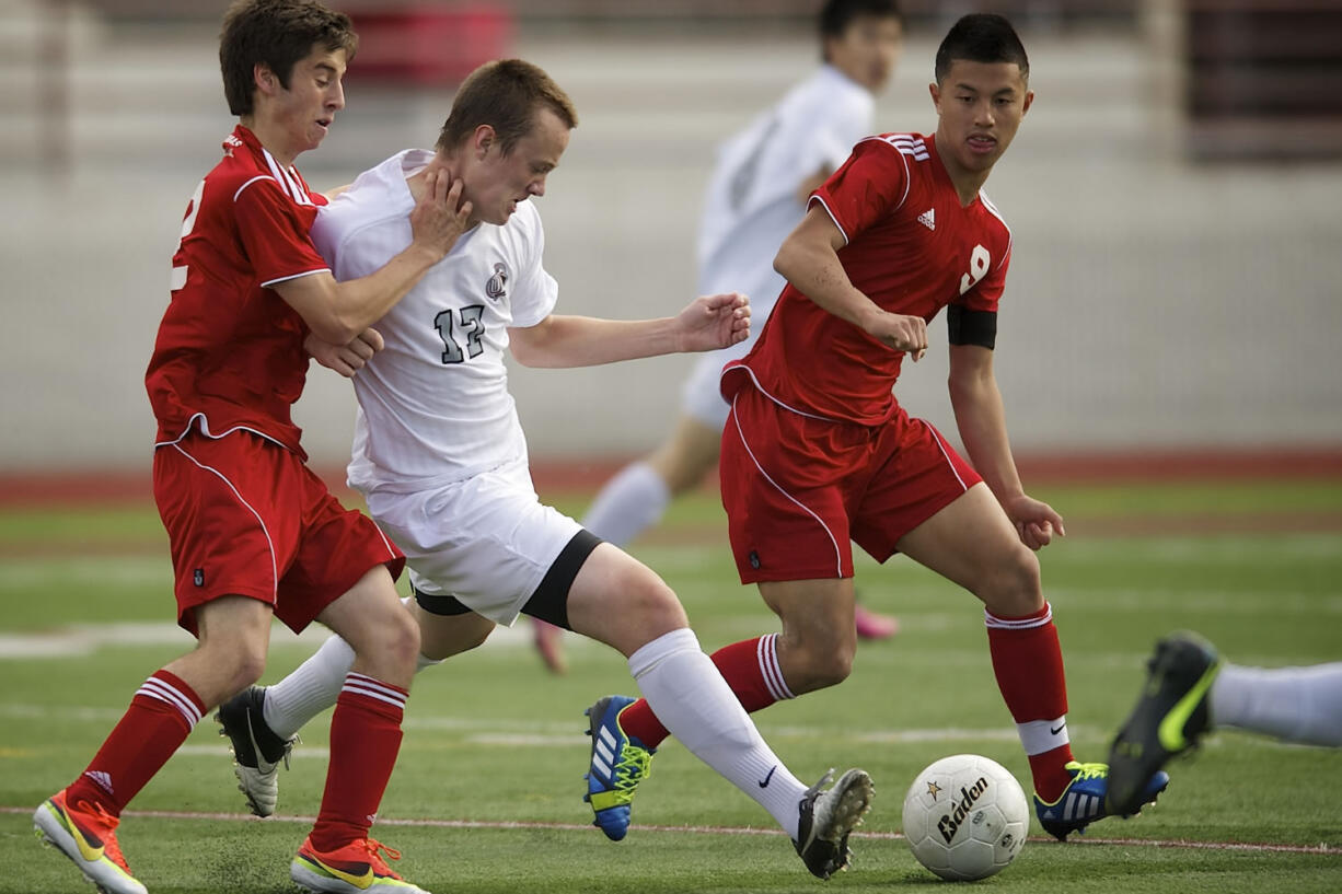 Union's Mitch Wheelon, center, battles for possession against Paul-Andrew McCleary, left, and Matthew Cruz, right, of Thomas Jefferson during the boys 4A State Soccer Championship game Saturday in Puyallup.