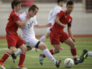 Union's Mitch Wheelon, center, battles for possession against Paul-Andrew McCleary, left, and Matthew Cruz, right, of Thomas Jefferson during the boys 4A State Soccer Championship game Saturday in Puyallup.