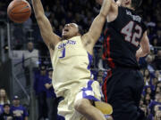 Washington's Abdul Gaddy, left, collides with Utah's Jason Washburn (42) under the basket in the second half  Saturday.