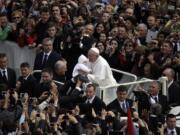 Pope Francis holds a baby Sunday after celebrating his first Easter Mass in St. Peter's Square at the Vatican. Pope Francis celebrated his first Easter Sunday Mass as pontiff in St. Peter's Square, packed by joyous pilgrims, tourists and Romans and bedecked by spring flowers. Wearing cream-colored vestments, Francis strode onto the esplanade in front of St.