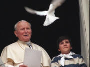 Pope John Paul II looks at a dove after he delivered the noon blessing from the window of his studio overlooking St. Peter's Square at the Vatican on Jan.