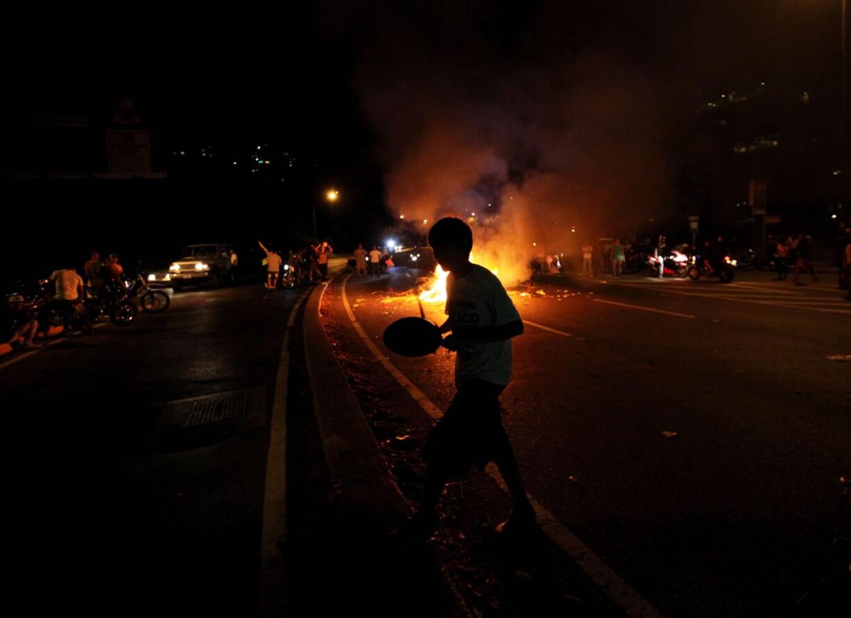 An opposition supporter bangs a pot in opposition of interim President Nicolas Maduro during a protest in Caracas, Venezuela, on Monday.