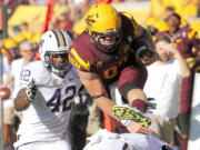 Arizona State tight end Chris Coyle leaps for extra yards as Washington linebacker Cory Littleton (42) defends during the first half of an NCAA college football game, Saturday, Oct. 19, 2013, in Tempe, Ariz.