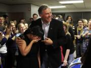 Jay Inslee wins the governor's race in Washington and puts his arm around Unjin Lee, a staffer who  is overcome with emotion that the race is finally resolved Friday.