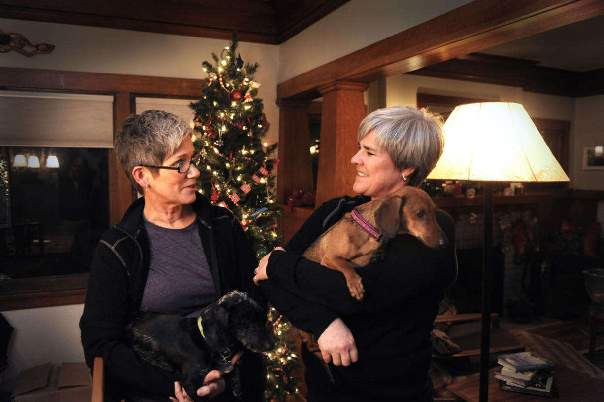 Former Army Major Margaret Witt, right, and Lori Johnson, left, stand in their home Monday in Spokane.