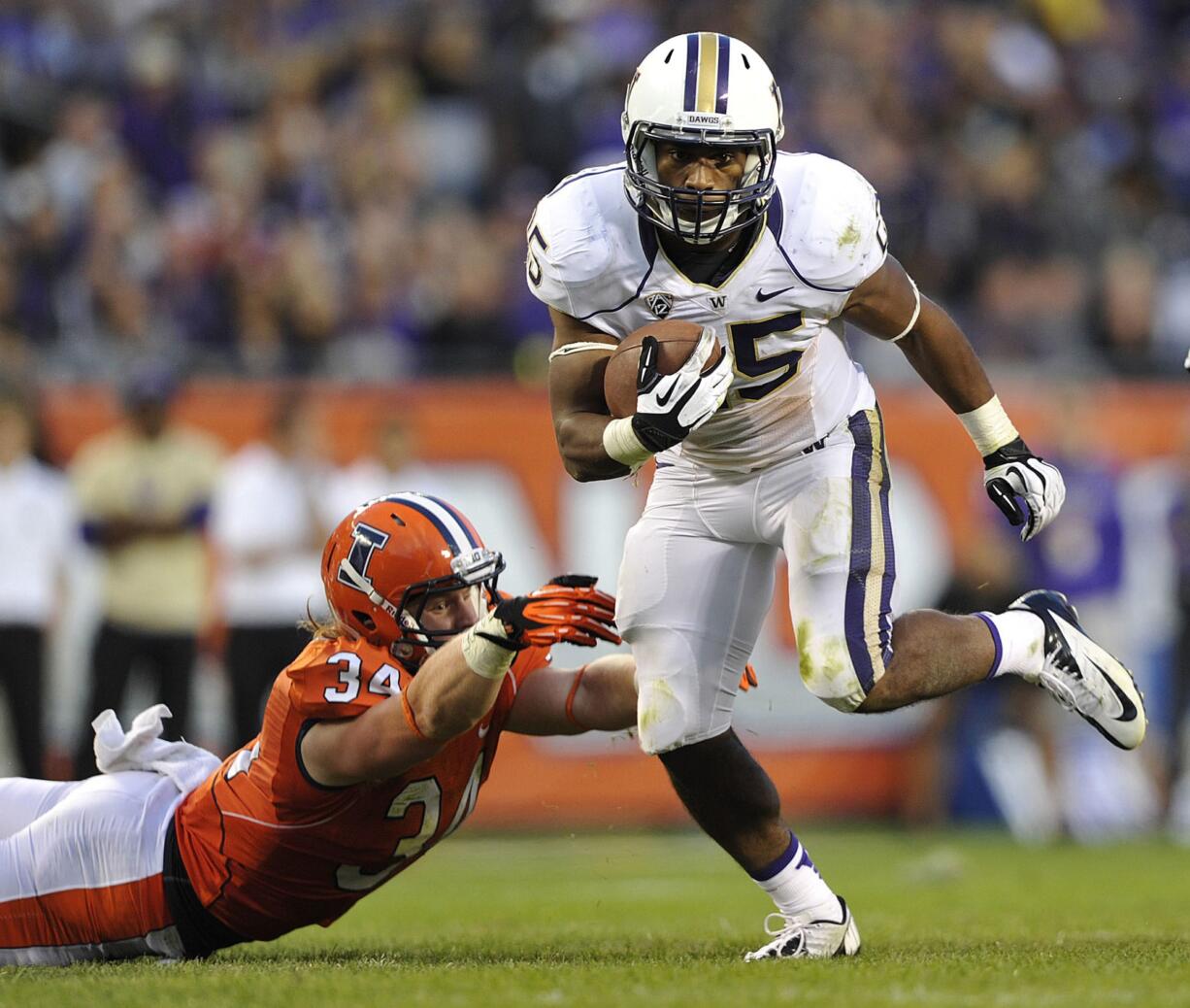 Illinois' Mike Svetina (34) misses the tackle as Washington's Bishop Sankey heads upfield during the second half  Saturday.