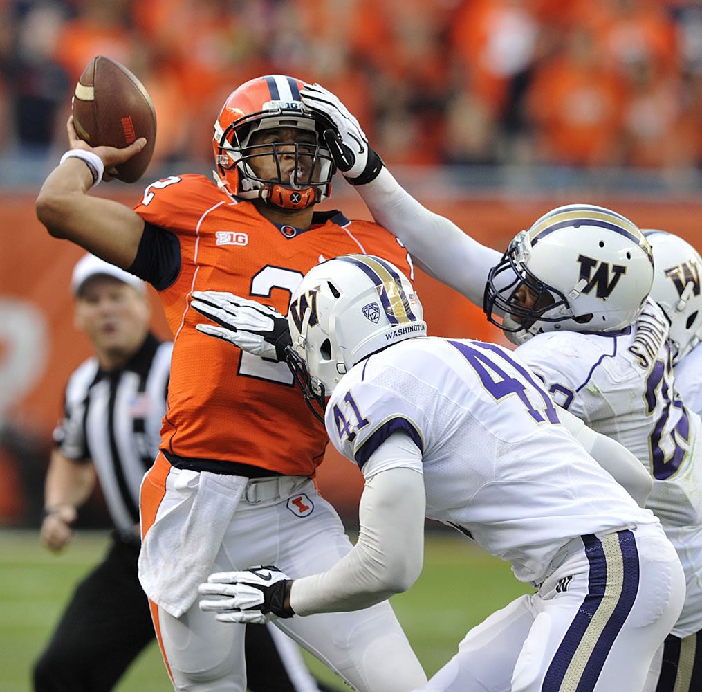 Illinois' Nathan Scheelhaase (2) gets defensive pressure from Washington's Travis Feeney (41) and Josh Shirley during the first half Saturday.