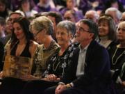 Carol James, center, surrounded by her children, Jeni Simmons, left, Jill Woodruff, and Jeff James, right, smile during remembrances of former University of Washington football coach Don James at his memorial service at Alaska Airlines Arena (HecEd Pavilion) in Seattle, Sunday Oct. 27, 2013. James passed away a week ago of pancreatic cancer at age 80.