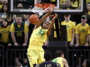 Oregon's Carlos Emory dunks in front of a the Pit Crew student section against Washington during the first half of an NCAA college basketball game in Eugene, Ore., Saturday, Jan 26, 2013.