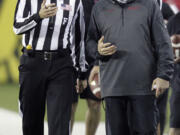 Washington State coach Mike Leach, right, questions a call with a referee during the second half of an NCAA college football game against Oregon in Eugene, Ore., Saturday, Oct. 19, 2013. Oregon won 62-38.