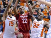 Washington State's Royce Woolridge (22) shoots against Oregon State's Eric Moreland (15) and Jarmal Reid (32) during the first half Saturday.