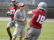 Washington State head coach Mike Leach, center, watches wide receivers Brett Bartolone, right, and Bobby Ratliff, left, run drills during the fall camp opening practice.