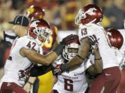 Washington State cornerback Damante Horton, middle, celebrates his interception with teammates Cyrus Coen, left, and Darryl Monroe during the second half of an NCAA college football game against Southern California in Los Angeles, Saturday, Sept. 7, 2013.