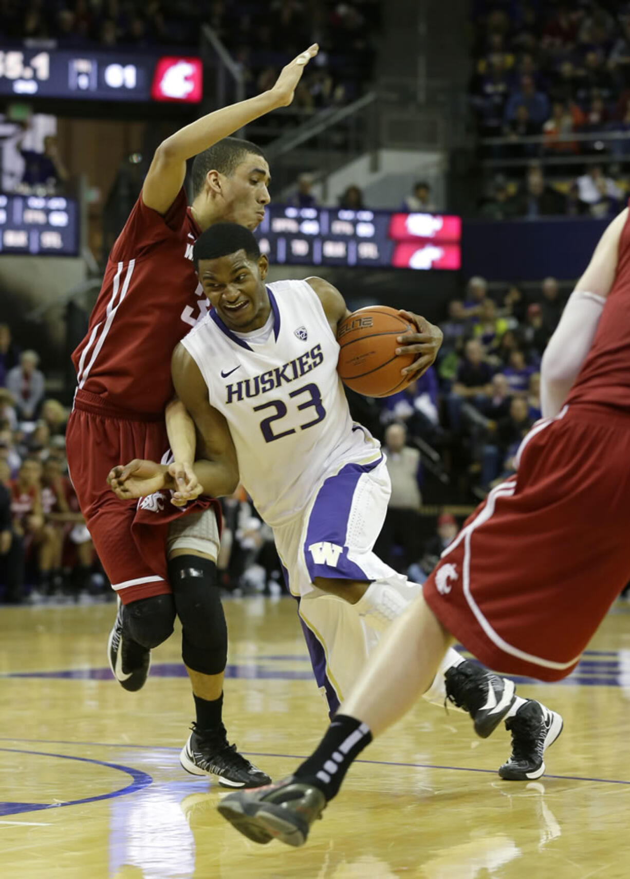 Washington's C.J. Wilcox (23) drives around Washington State's Dexter Kernich-Drew, left, in the second half Sunday.