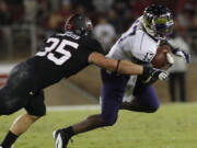 Washington quarterback Keith Price, right, is tackled by  Stanford's Jarek Lancaster during the second half of an NCAA college football game in Stanford, Calif., Saturday, Oct. 5, 2013.