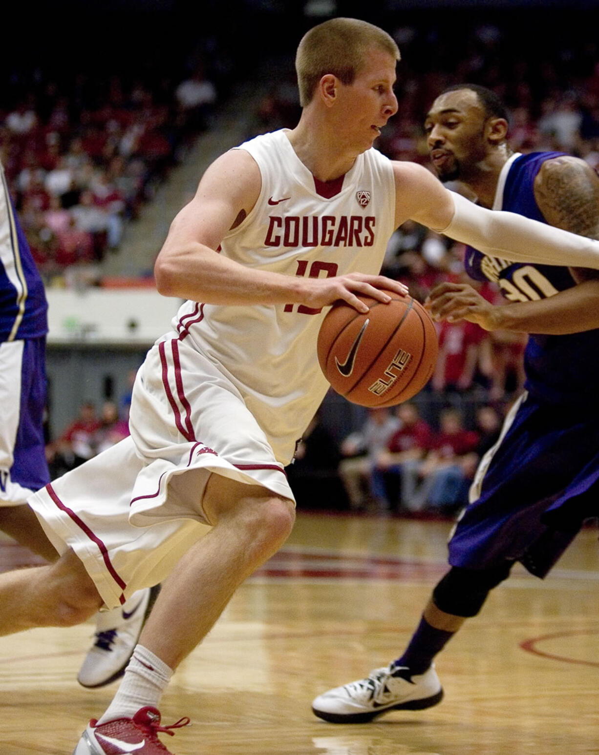 Washington State forward Brock Motum (12) drives against Washington forward Desmond Simmons (30) during the first half Saturday.