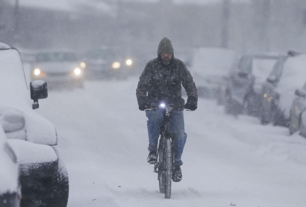 Bundled against high winds, a bicyclist struggles down Washington Street early Tuesday in Denver. Forecasters predict that four to 10 inches of snow will blanket Colorado&#039;s eastern plains before the storm, which started Monday in the intermountain West, moves to the east.