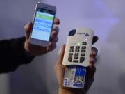 A man uses the &quot;Paypal here&quot; system of payment with a phone Wednesday at the Mobile World Congress in Barcelona, Spain.