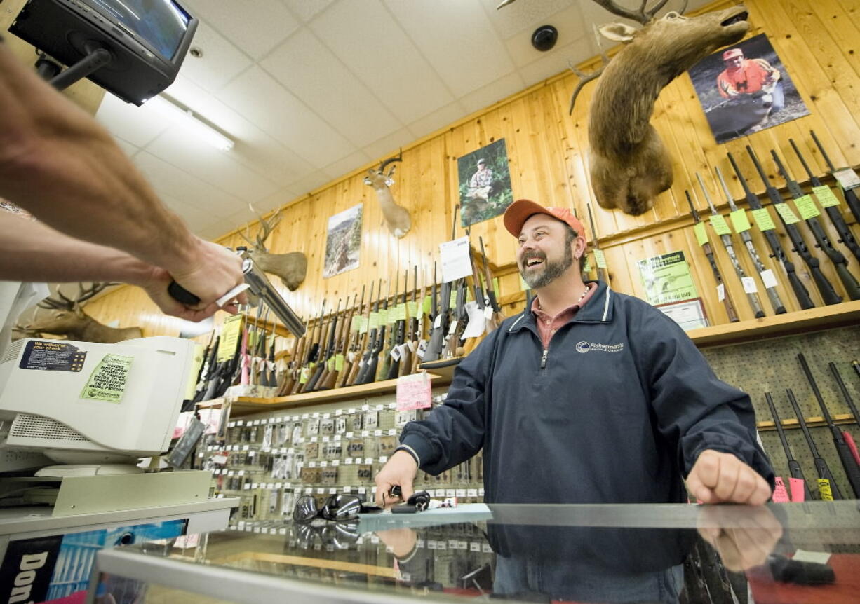 Fisherman's Marine and Outdoor store manager John Thompson shows a handgun to a customer in November 2008, when local gun sales spiked after the presidential election.