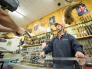 Fisherman's Marine and Outdoor store manager John Thompson shows a handgun to a customer in November 2008, when local gun sales spiked after the presidential election.