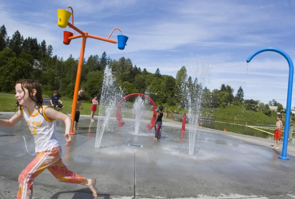 Children play in the spray park during a recent summer at Klineline Pond.